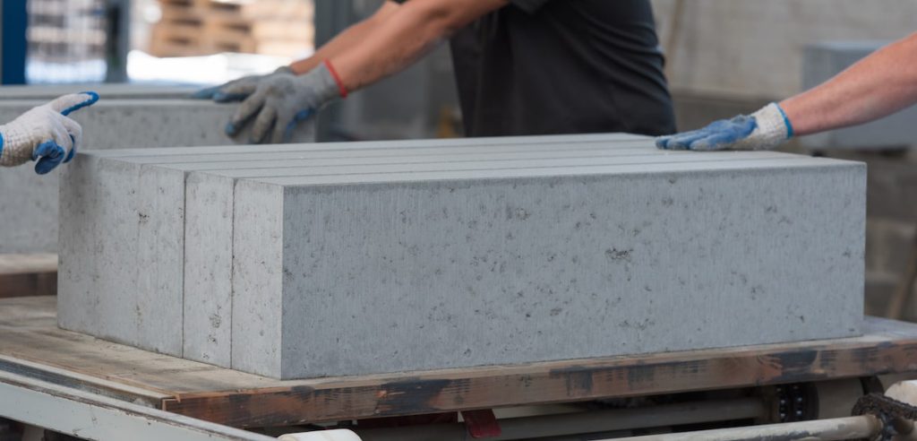 Concrete suppliers placing big blocks of concrete on surface.