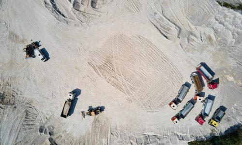 Aerial view of trucks positioned around a large quarry site extracting silica and porcelain-grade sand in Florida.